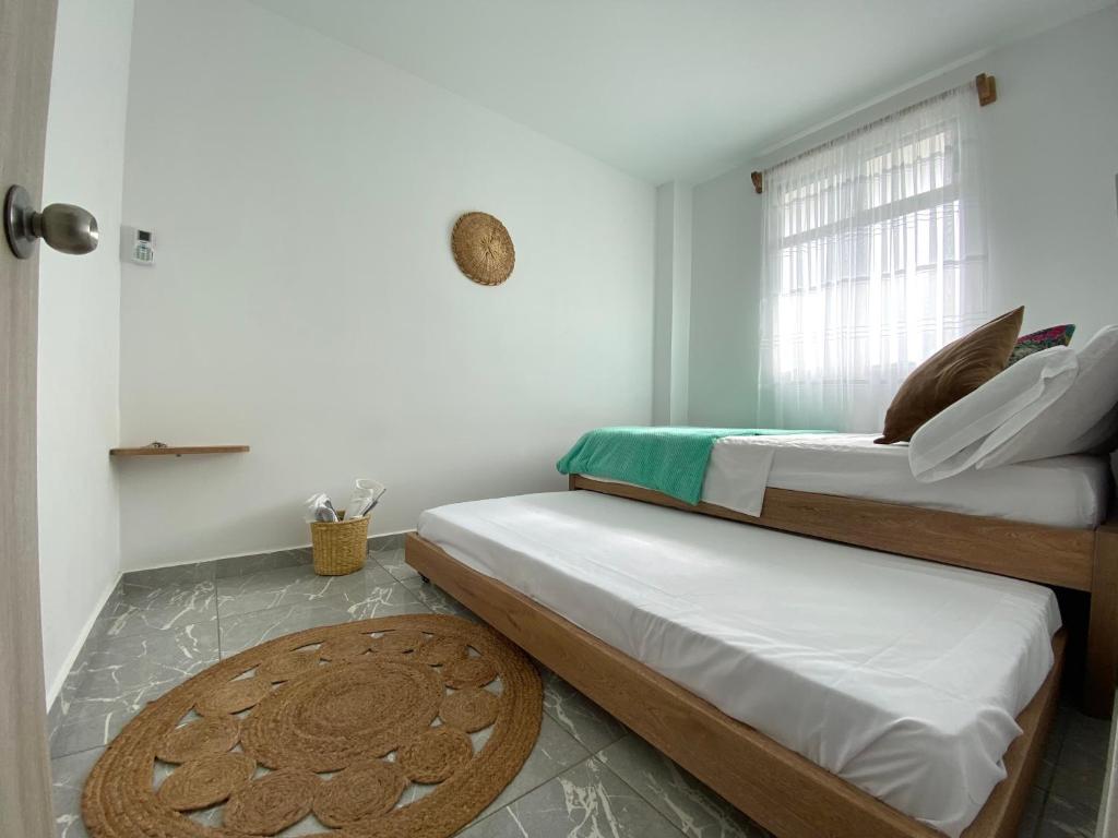 - 2 lits dans une chambre avec fenêtre dans l'établissement Apartamento en condominio con vista al mar, à San Bernardo del Viento