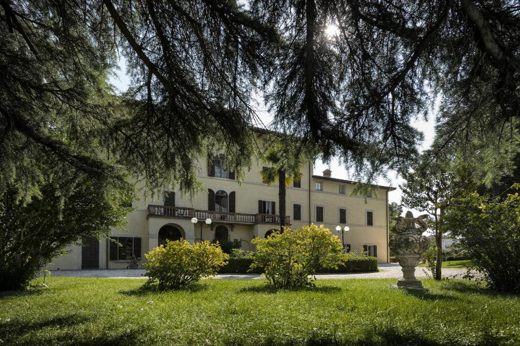 un grand bâtiment blanc avec des arbres au premier plan dans l'établissement Posta Donini 1579 - UNA Esperienze, à San Martino in Campo