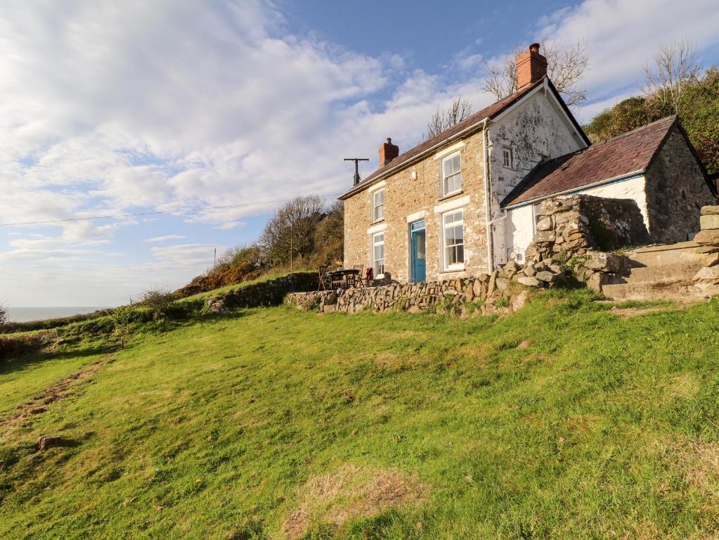 LlandysulにあるDolwylan Cottageの草原の古石造りの家