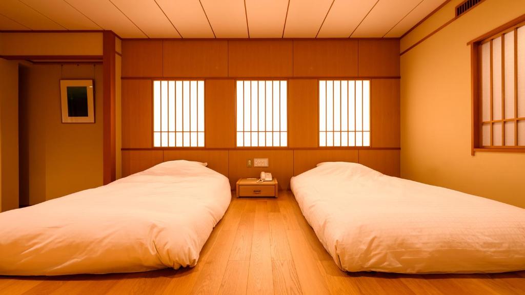 Postel nebo postele na pokoji v ubytování Tamaya Ryokan