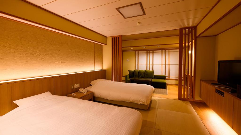 Postel nebo postele na pokoji v ubytování Tamaya Ryokan