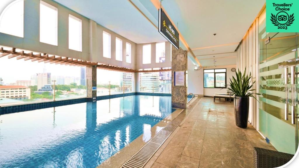 a large swimming pool in a building with windows at Muong Thanh Grand Saigon Centre Hotel in Ho Chi Minh City