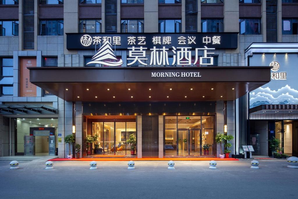 un edificio con una señal para un hotel giratorio en Morning Hotel, Changsha Avenue Metro Station High -speed Railway Station, en Changsha