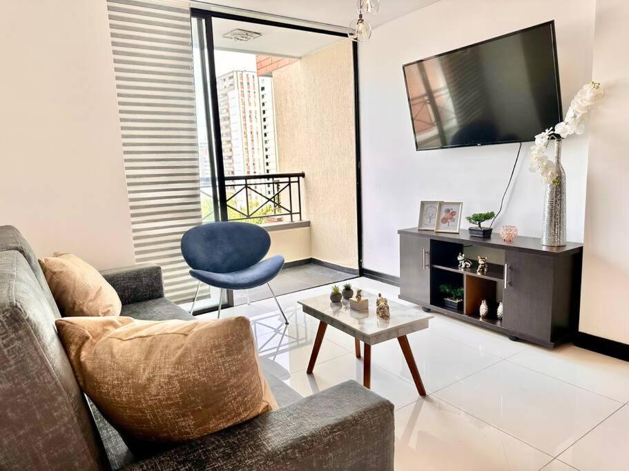sala de estar con sofá, mesa y TV en Apartamento hermoso central, en Bucaramanga