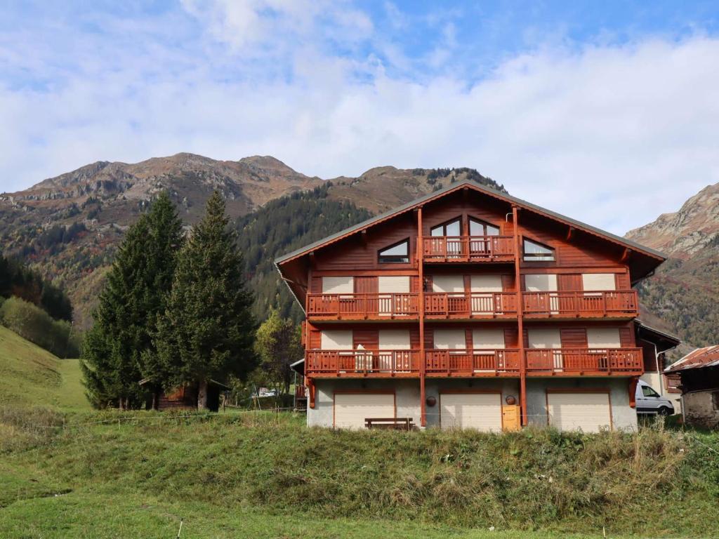 une maison en bois sur une colline avec des montagnes en arrière-plan dans l'établissement Appartement au pied des pistes, terrasse, calme, 4 pers, Arêches-Beaufort - FR-1-342-287, à Beaufort