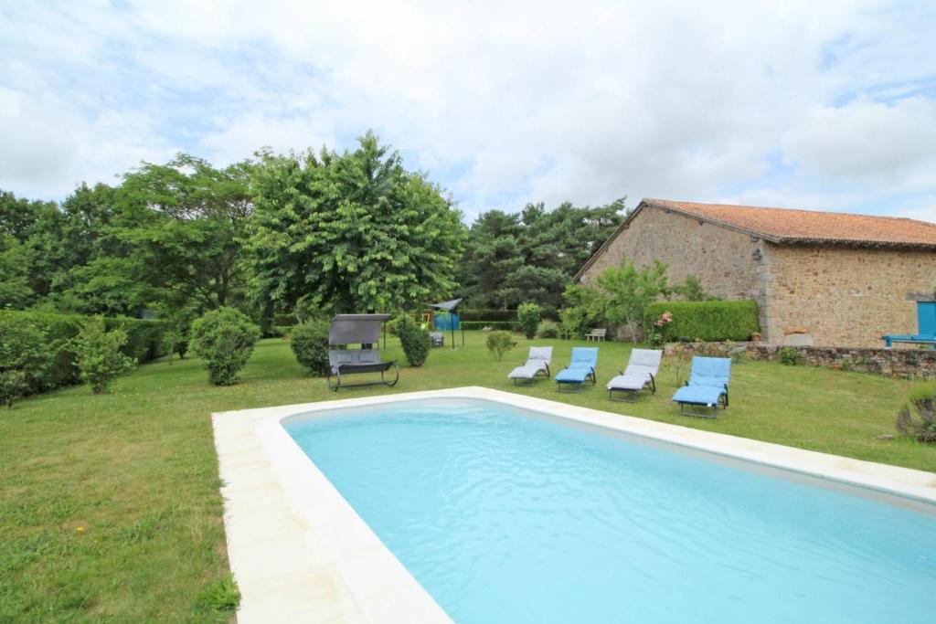 una piscina en un patio con sillas y una casa en Lascaux, en Marval