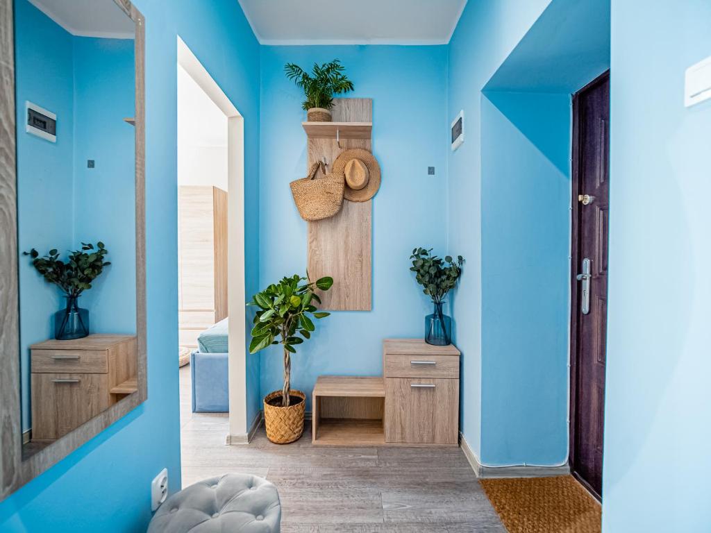 un pasillo con paredes azules y espejo en Apartament The Middle One (Train Station - 500m, The Beach - 900 m) en Gdynia