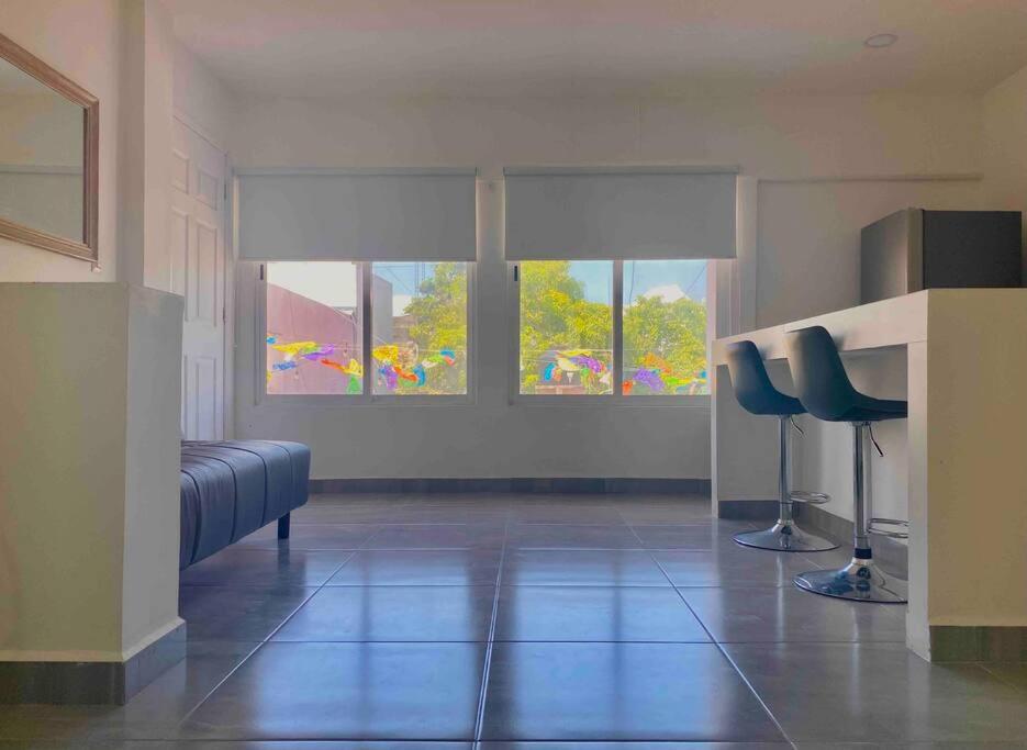 a room with two blue chairs and two windows at 5th Av Studio Close to the Beach ADO Ferry & Mall in Playa del Carmen