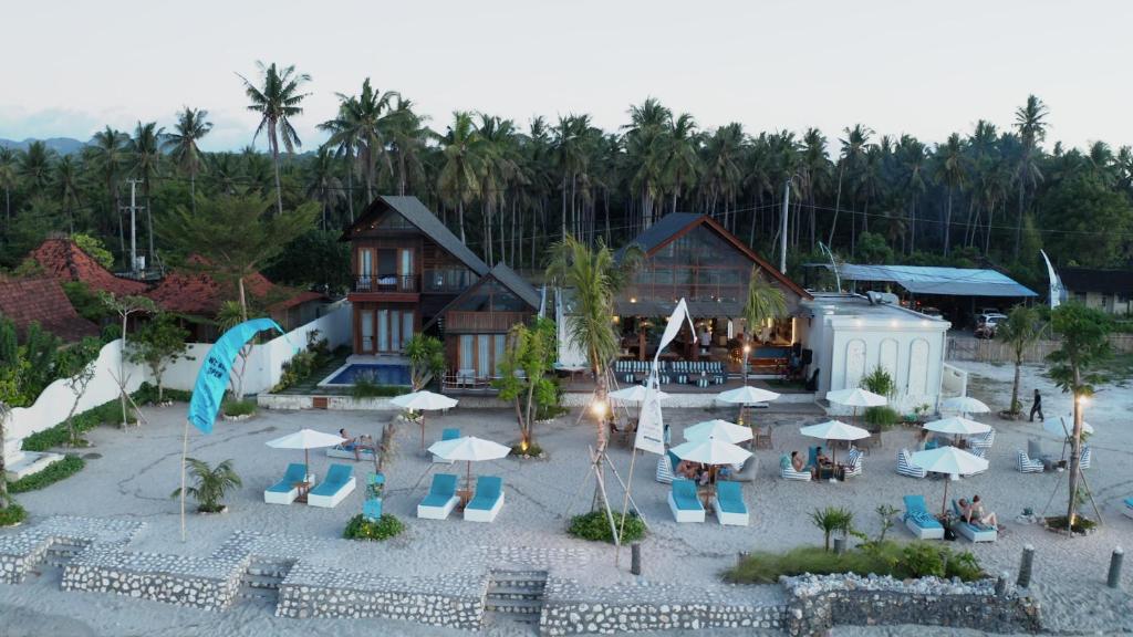 ペニダ島にあるKhamara Nusa Penidaのリゾートの空中を望む客室で、椅子とパラソルが備わります。