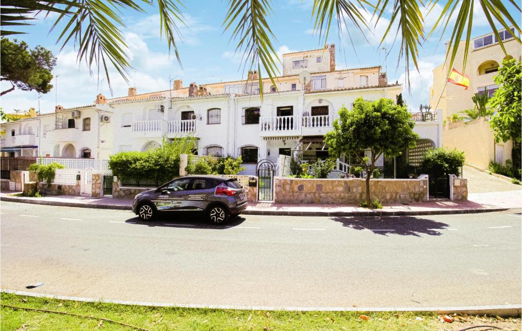 オリフエラ・コスタにあるCozy Home In Orihuela Costa With Kitchenの白い建物の前に停車する車