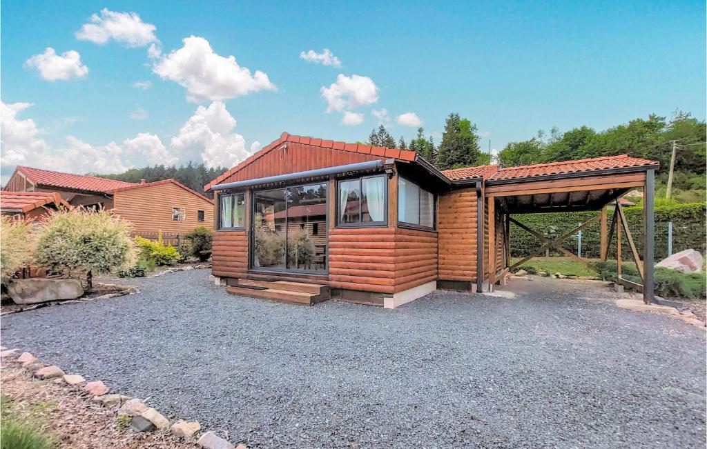 une maison en bois avec une grande fenêtre sur une allée en gravier dans l'établissement Stunning Home In Corcieux With Kitchen, à Corcieux