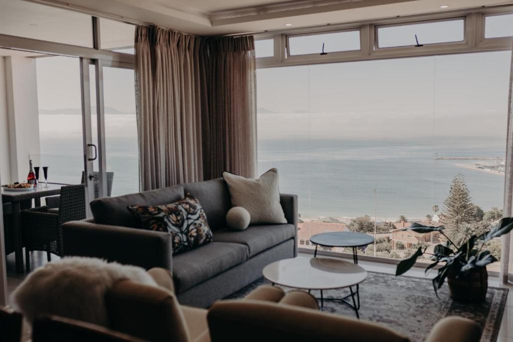 a living room with a couch and a large window at View @ The Bay Apartments 9 in Mossel Bay