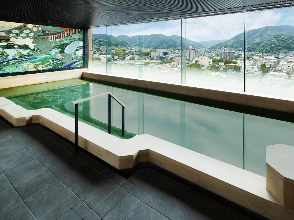 a swimming pool in a building with a view at Hotel Sakura Ureshino in Ureshino