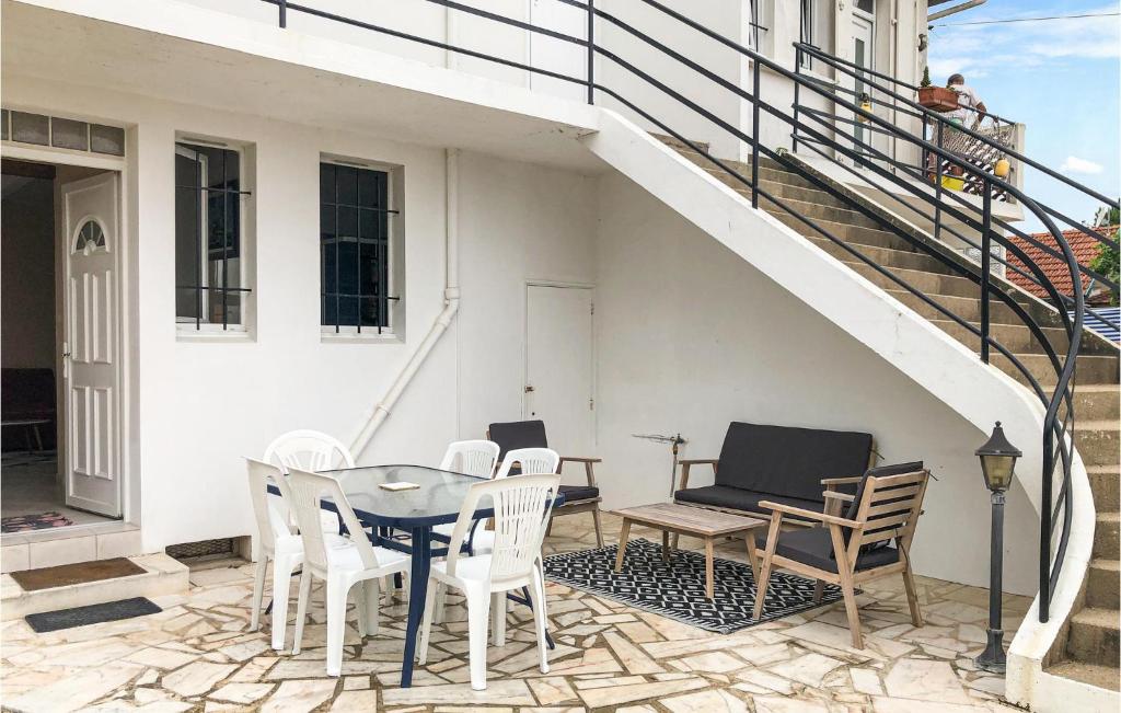 d'une terrasse avec une table, des chaises et des escaliers. dans l'établissement Gorgeous Home In La Faute Sur Mer, à La Faute-sur-Mer