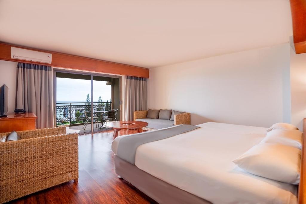 a hotel room with a large bed and a balcony at Nouvata in Noumea