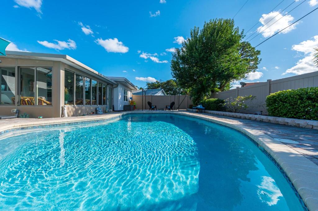 a swimming pool in the backyard of a house at Grand Pool Villa Minutes to the Beach! Sleeps 8! in Boynton Beach