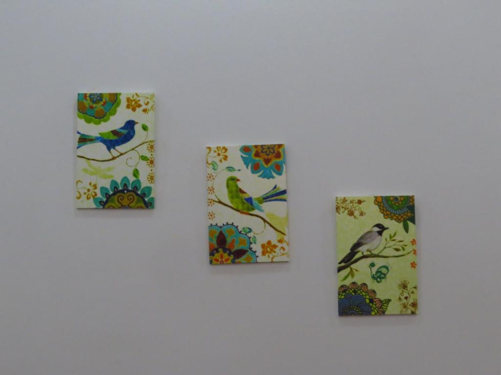 four paintings of birds on a white wall at HO GIA AN Home - Double Room in Can Tho