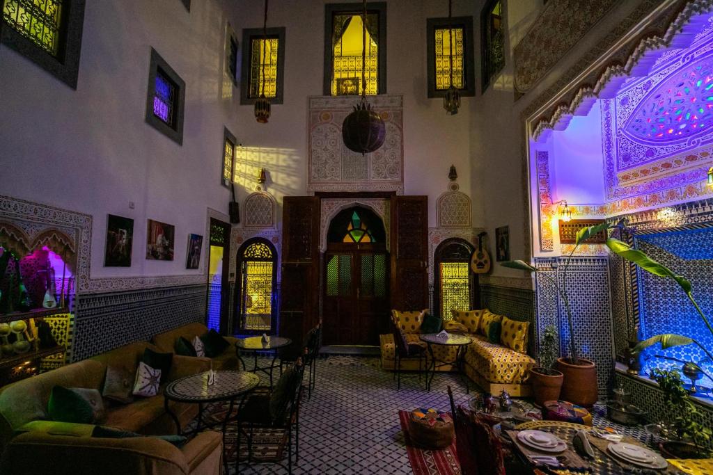 um restaurante com mesas e cadeiras num quarto em Riad Tarab Fes em Fez