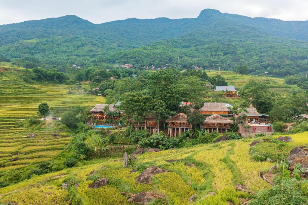 a village on a hill with mountains in the background at Puluong Valley Home in Thanh Hóa