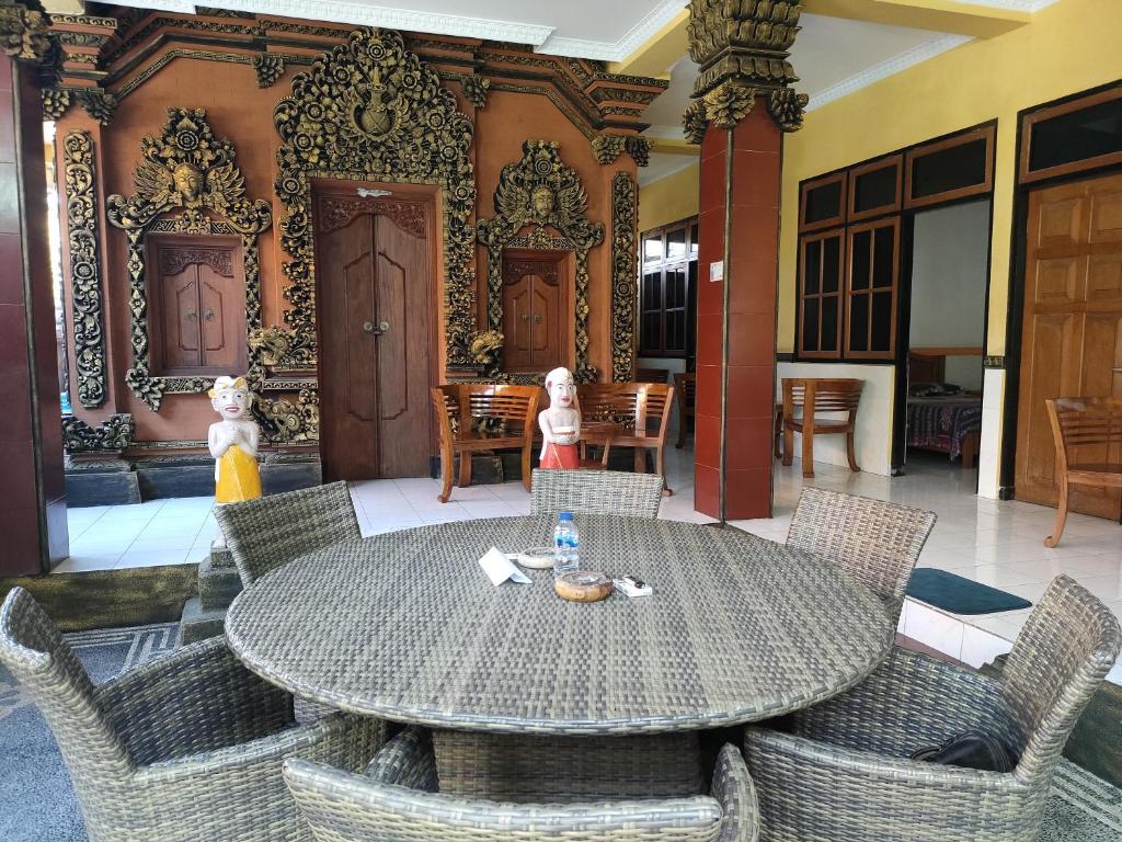 a dining room with a table and chairs with dolls at Dharma homestay in Padangbai