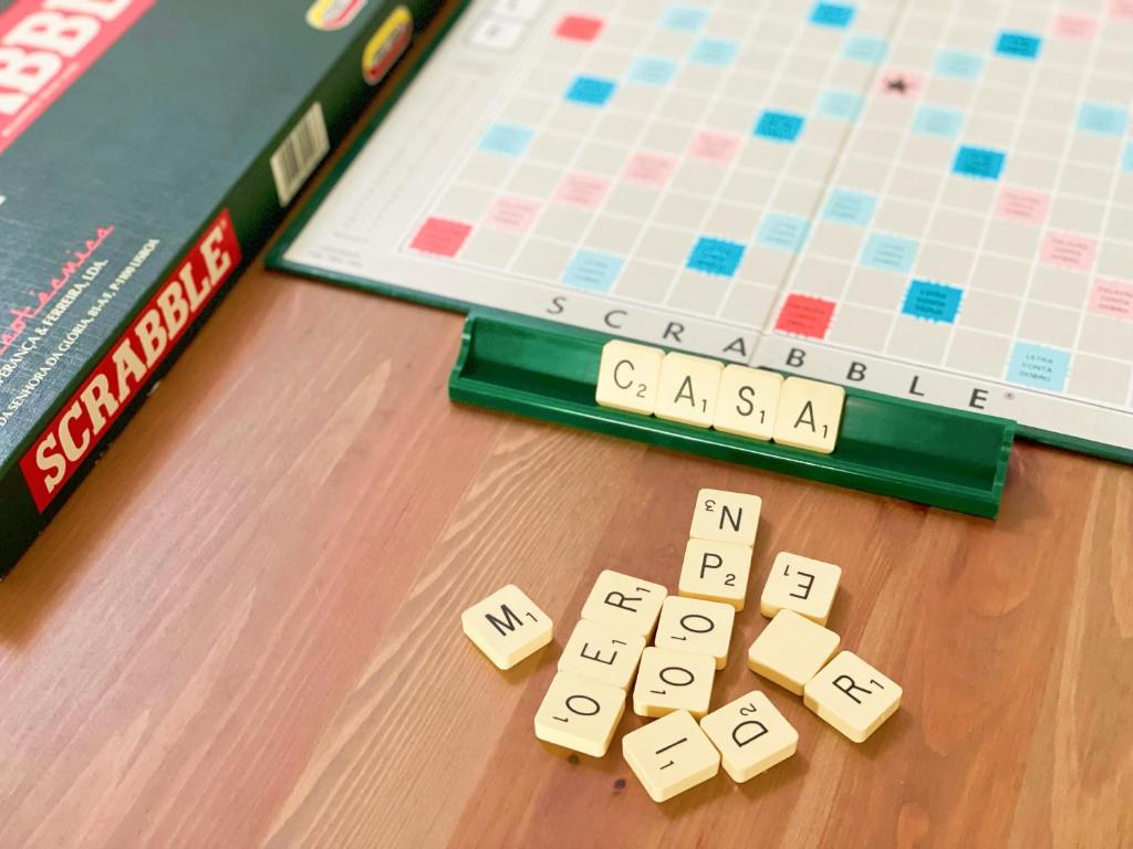 a scrabble board game and a book on a table at Casa de Partida in Covilhã