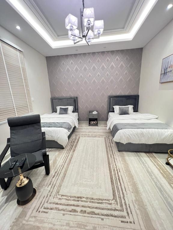 Un dormitorio con 2 camas y una silla. en تم الحذف en Yeda