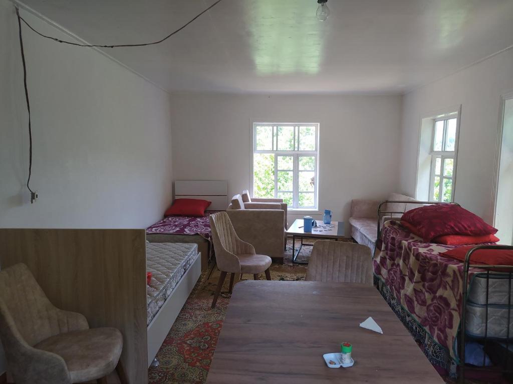 een kamer met een bed en een tafel en stoelen bij Ruzigar Guesthouse in Sım