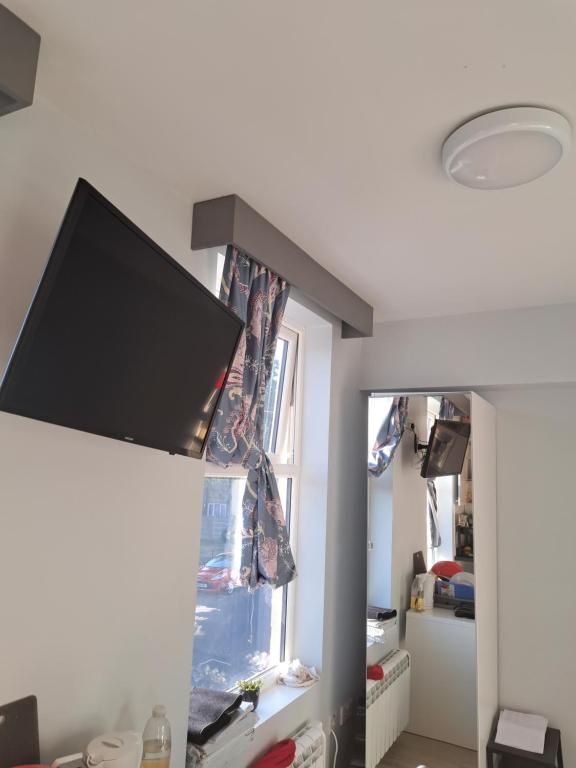 ein Wohnzimmer mit einem Flachbild-TV an der Wand in der Unterkunft Mo's Room in London