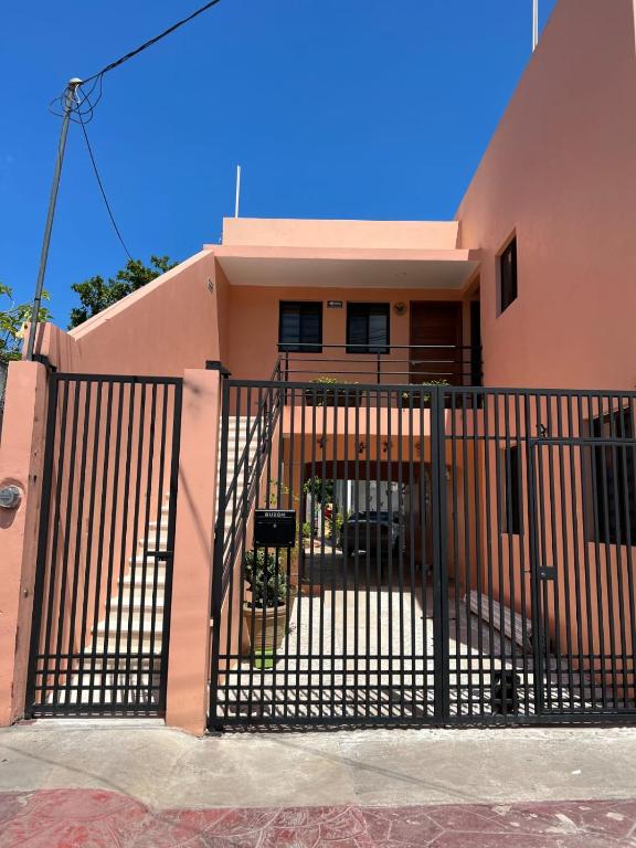 a pink house with a gate in front of it at rooms7 in Bacalar