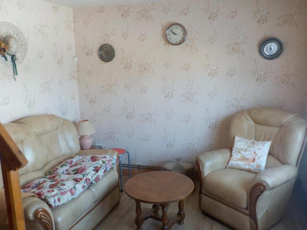 ein Wohnzimmer mit 2 Stühlen und einem Tisch in der Unterkunft 618 rue de l argiliere Helfaut 62570 