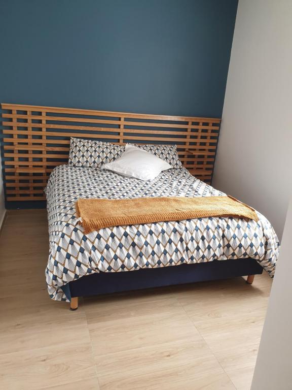 a bedroom with a bed with a wooden headboard at Luxueux appartement front mer in Sidi Rahal