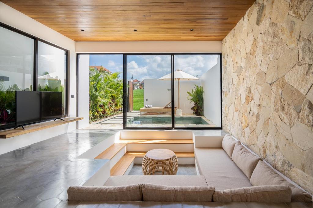un soggiorno con divano e una grande finestra di Elba Villa by Hombali a Canggu