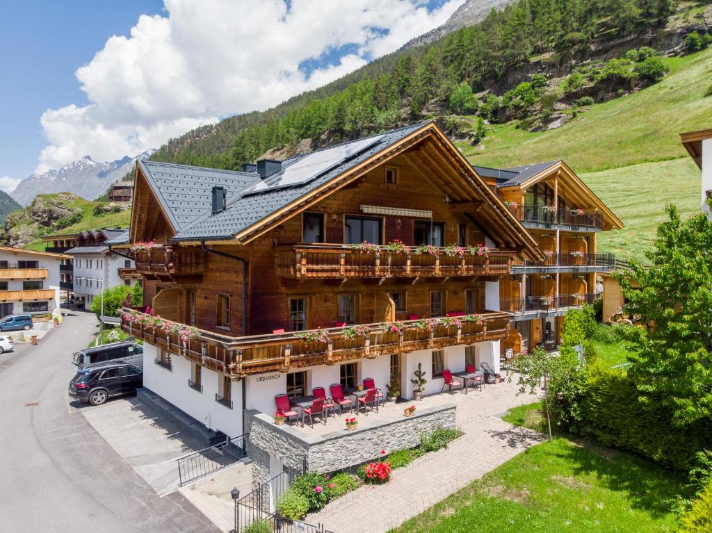a wooden house with a balcony and tables and chairs at Urbanhof in Sölden