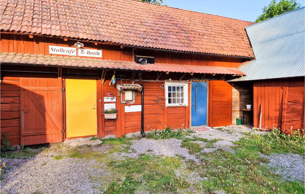 a wooden house with colorful doors on it at Amazing Apartment In Vedum With Kitchen in Vedum