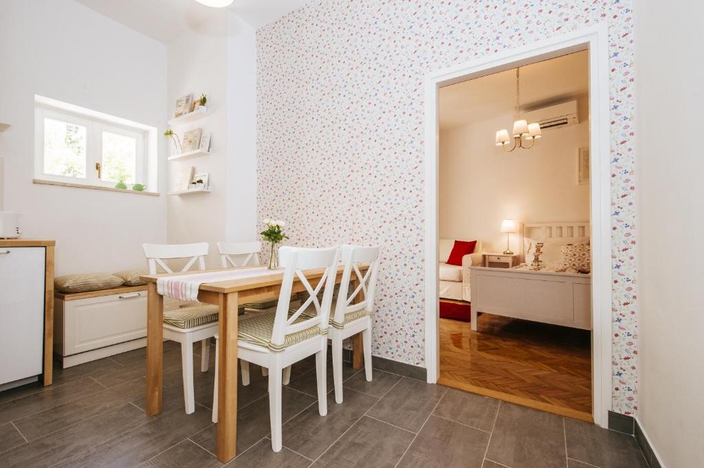 een eetkamer met een tafel en stoelen en een slaapkamer bij Apartments Jadera in Zadar