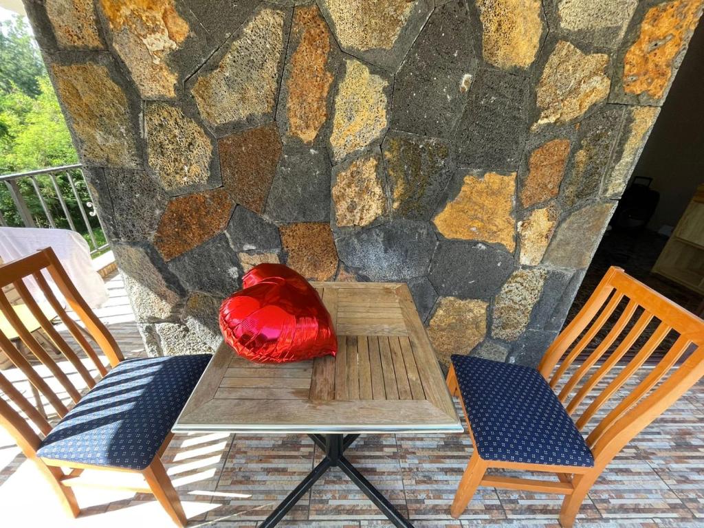 a red pillow sitting on a table next to two chairs at Riambel Paradise Inn Primary Apartment in Riambel