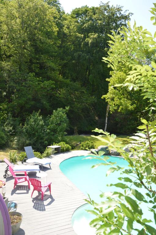 eine Terrasse mit Stühlen und einem Pool in der Unterkunft Moulin de la Cuse - L'îlote in Cusance