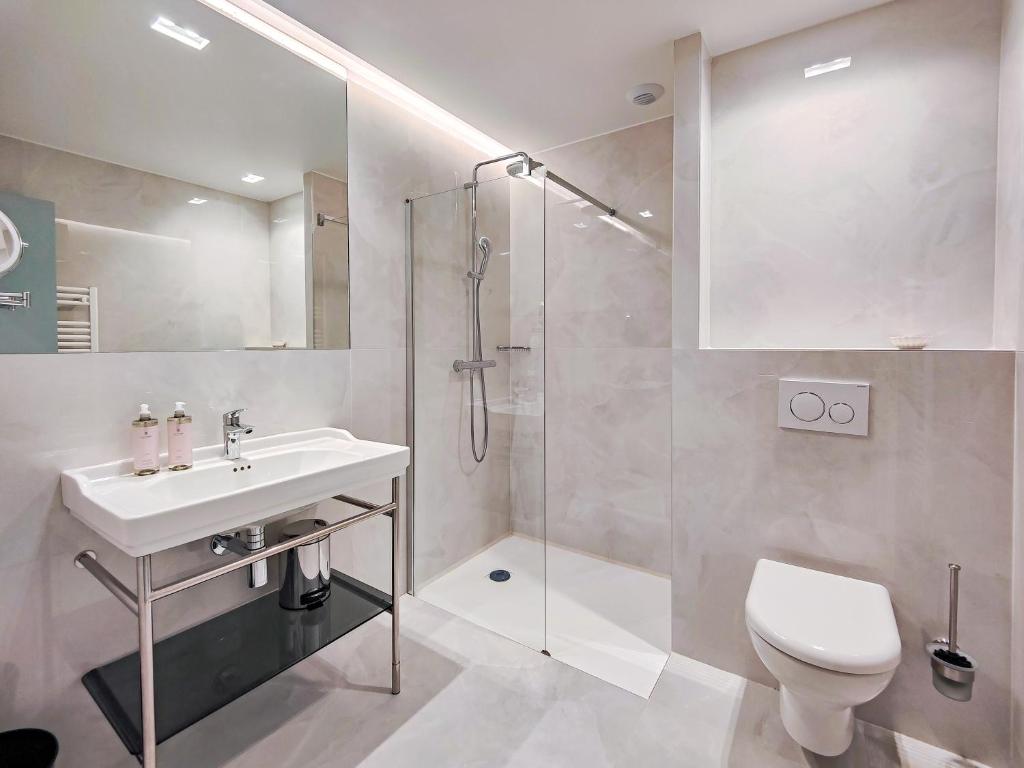a bathroom with a shower and a sink and a toilet at Aparthotel AMMI Nice Lafayette in Nice
