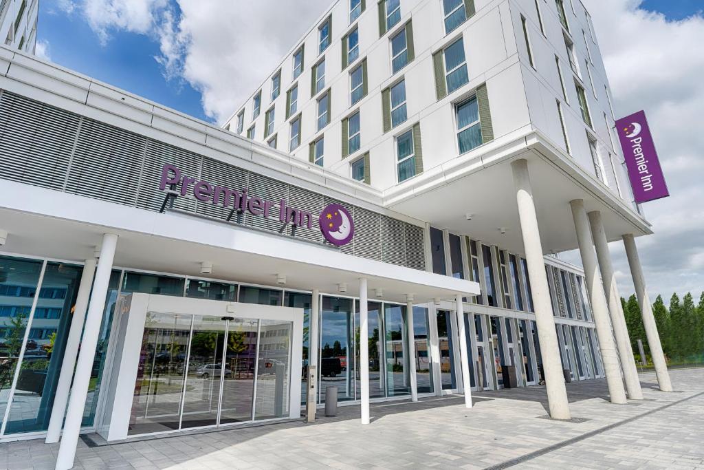 un gran edificio blanco con un letrero púrpura. en Premier Inn Wolfsburg City Centre en Wolfsburg