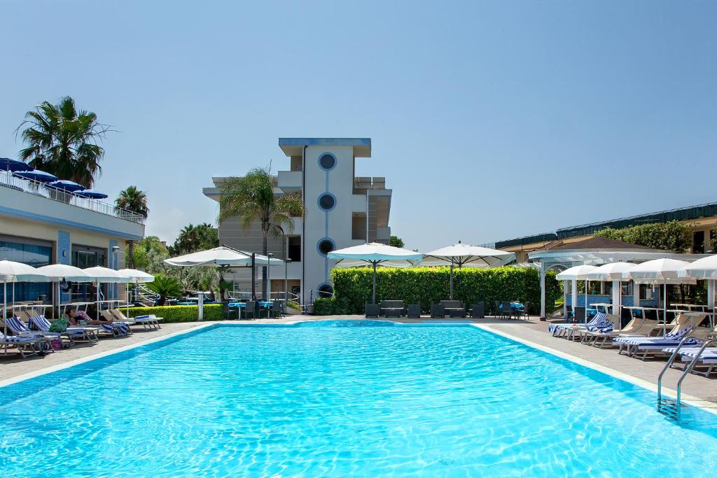 a swimming pool with chairs and umbrellas at a hotel at Hotel Premiere Pool & Resort in Marina di Varcaturo