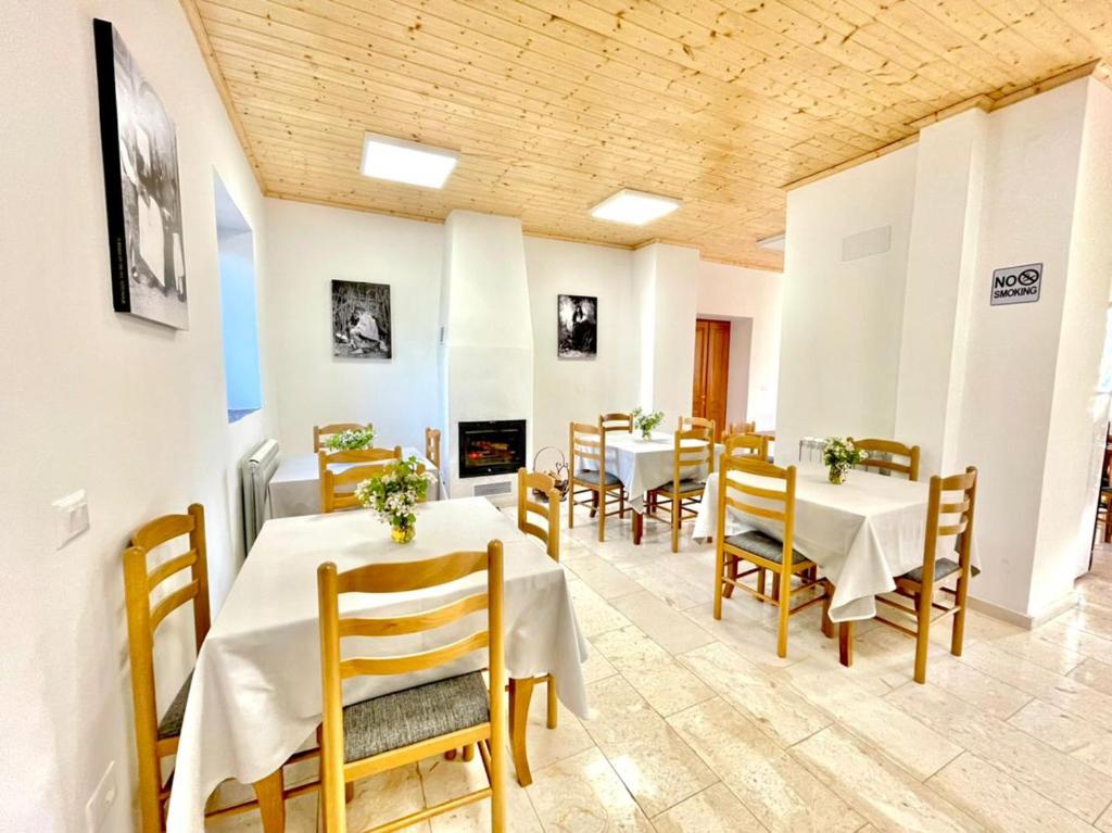 VermoshHotel Vermoshi TDC的一间带桌椅和壁炉的用餐室