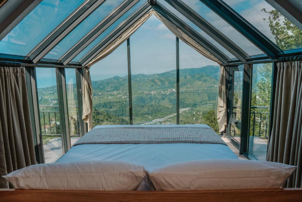 a bedroom with a bed in front of a window at Woodlife Bungalov in Ardeşen