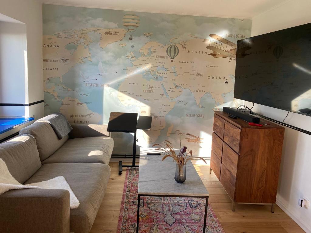 una sala de estar con un mapa grande en la pared en Schöne Wohnung mit Elbblick in Blankenese Strandlage en Hamburgo