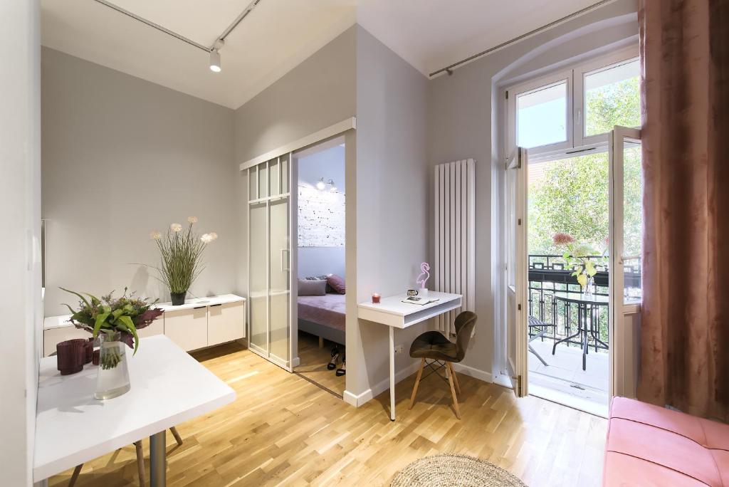 a living room with a desk and a balcony at Fair Point in Poznań