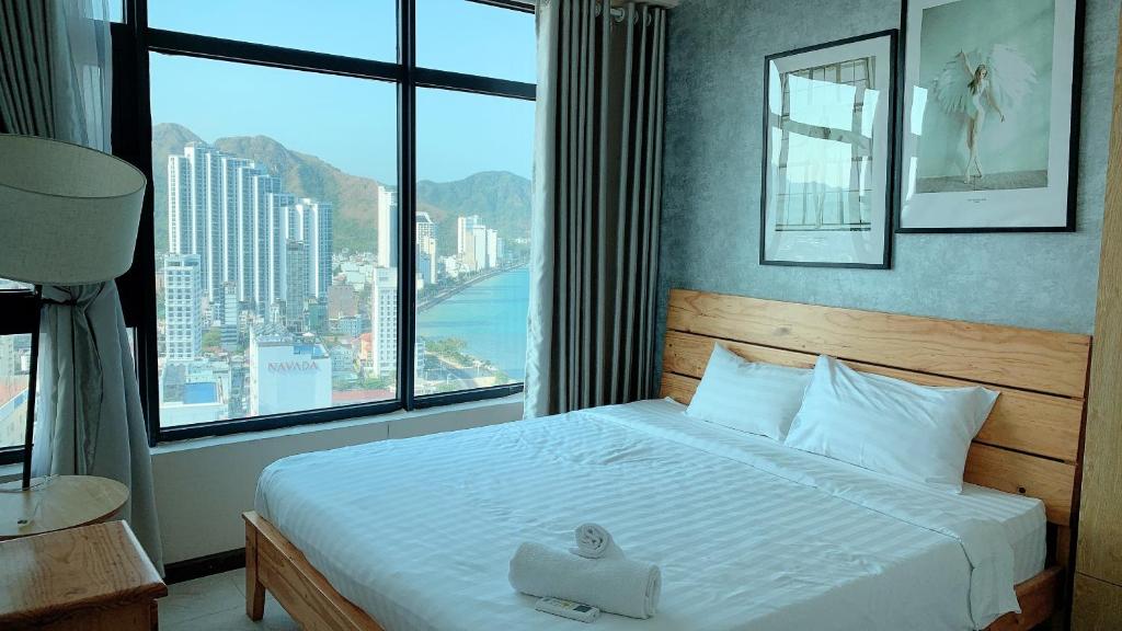 a bedroom with a bed with a large window at An's Oceanus in Nha Trang