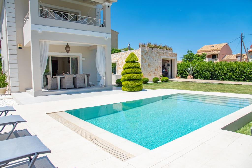 a villa with a swimming pool and a house at Luxury Seaside Villa DARL in Corfu Town