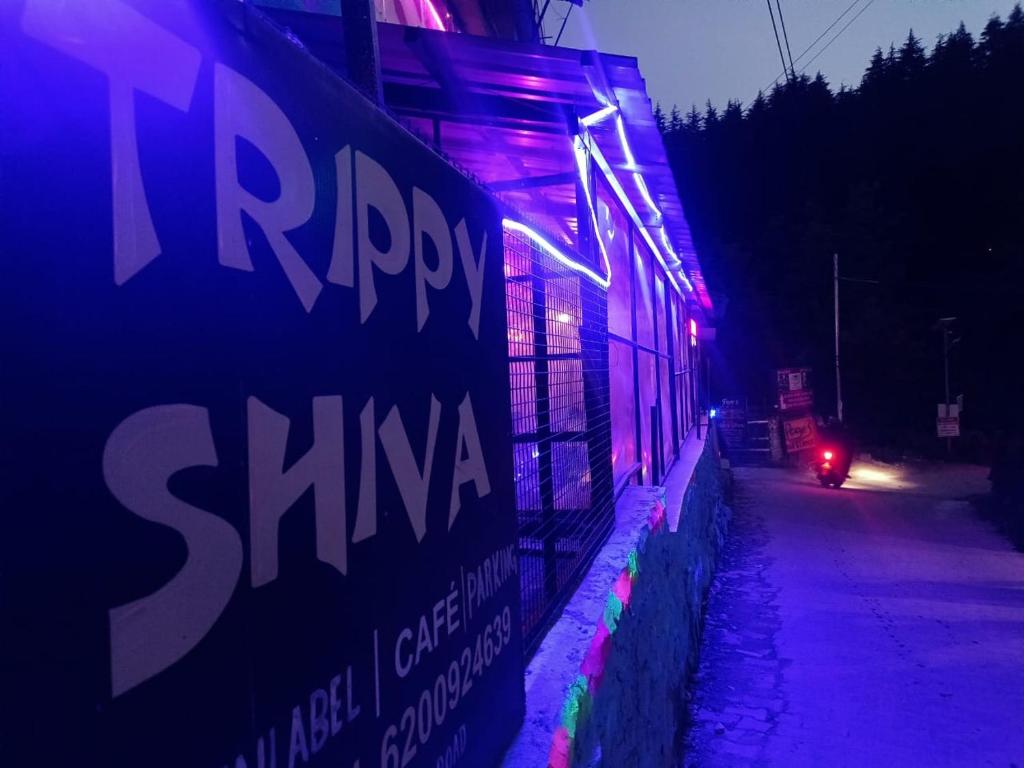 マナリにあるTrippy Shiva Hostelの紫色の灯りが横に見える建物