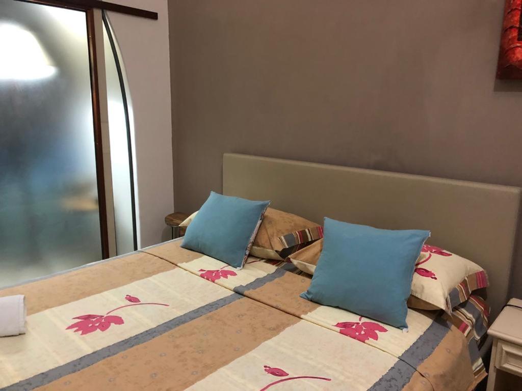 a bedroom with a bed with blue pillows at casa gramazio in Manfredonia