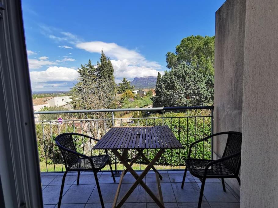 a table and chairs on a balcony with a view at Appartement 2 personnes in Trets