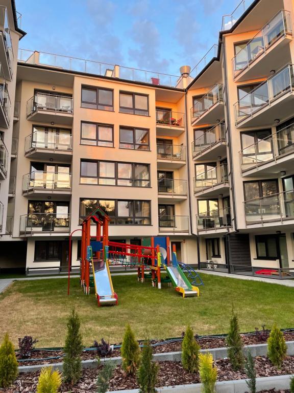 un parque infantil frente a un edificio de apartamentos en Apartament przy plaży - Rowy, en Rowy